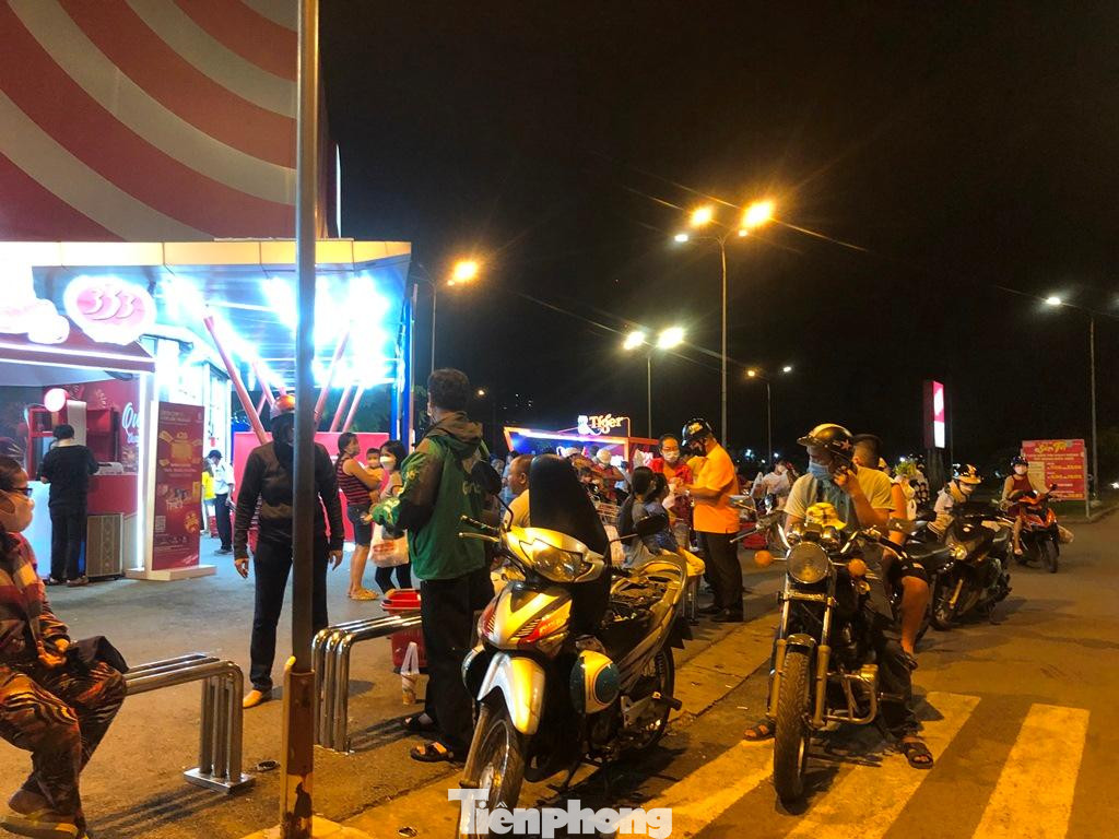 Bên ngoài, dòng người chờ đợi người nhà đi siêu thị cũng xếp hàng dài ngóng người thân.