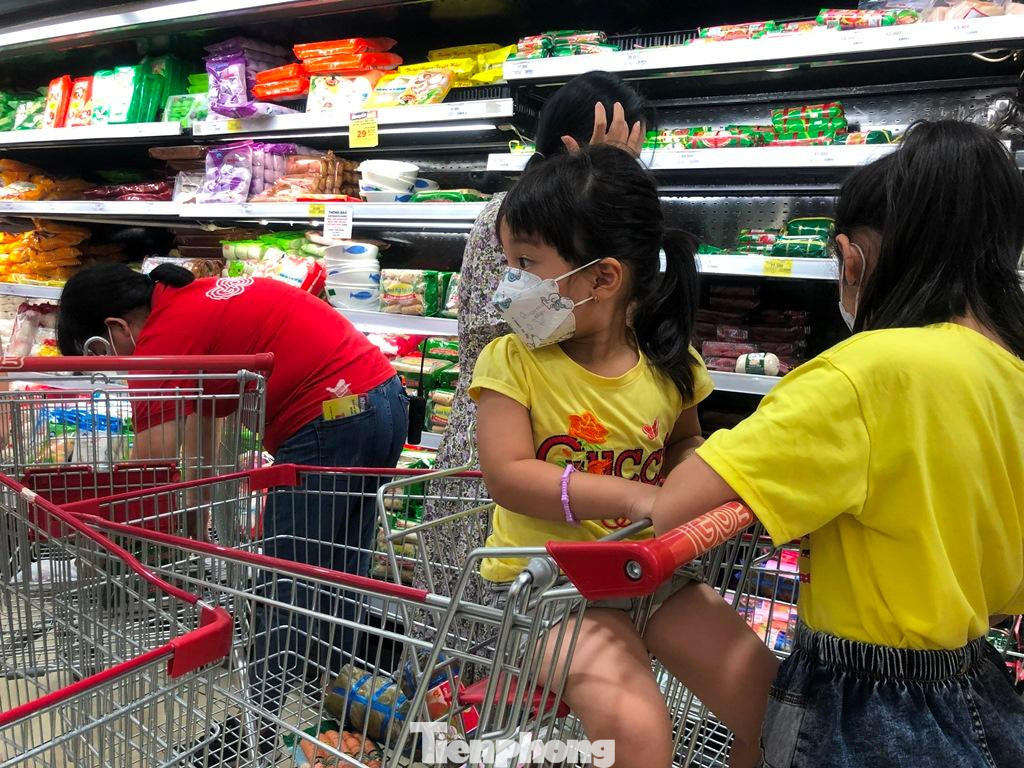 Rất đông trẻ em theo cha mẹ đi siêu thị lúc nửa đêm.