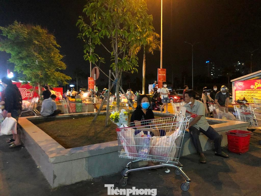 Sau thời gian dài chờ đợi mua sắm, khách hàng ngồi bệt bên ngoài để nghỉ mệt