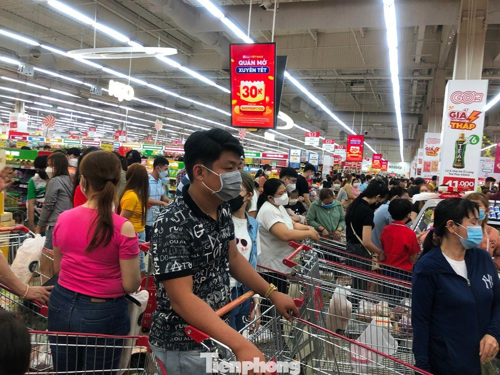 Một bảo vệ của siêu thị cho hay, cả tuần nay, từ sáng sớm đến tối muộn đều kẹt cứng ở khu vực thanh toán như vậy; dù siêu thị đã mở hết các quầy thanh toán nhưng do khách quá đông nên khách phải chờ đợi khá lâu. &quot;Siêu thị đóng cửa lúc 23 giờ nhưng tới 0 giờ vẫn chưa thanh toán đơn hàng cho hết khách hàng đang chờ đợi&quot; - bảo vệ siêu thị nói.