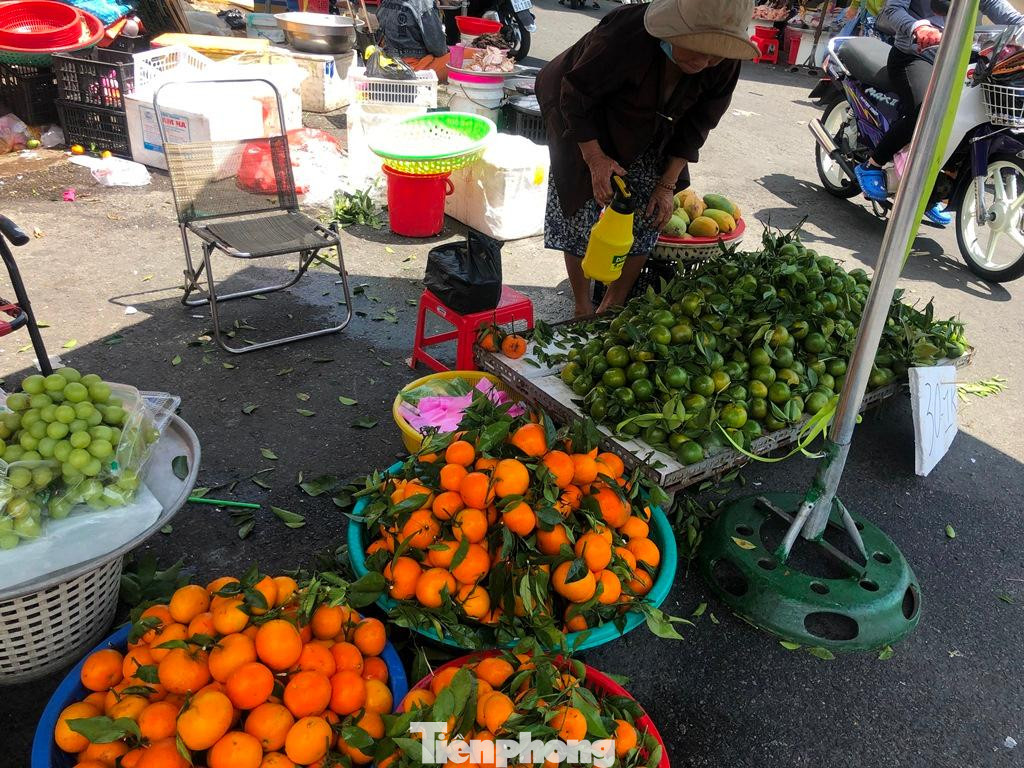 Tiểu thương tiếp thêm nước để giữ tươi trái cây giữa trưa nắng nóng