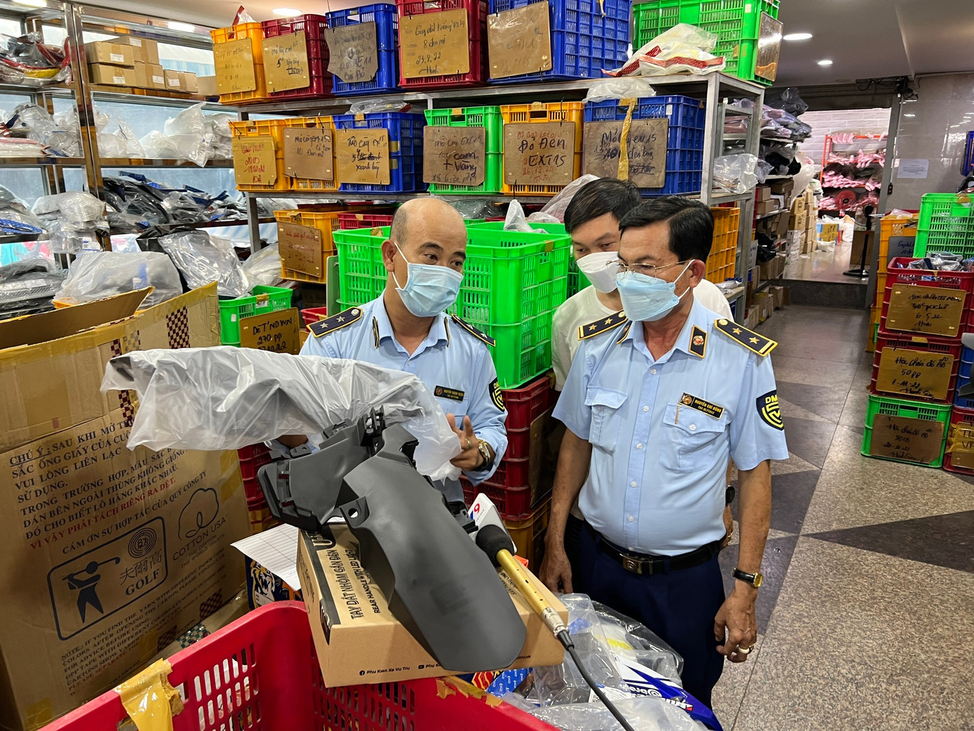 Lực lượng Quản lý thị trường đang làm việc với đại diện cửa hàng kinh doanh phụ tùng xe máy trong chợ Tân Thành