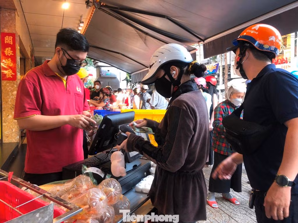 Các tiệm heo, vịt quay nổi tiếng đều tấp nập khách trong ngày Thần Tài. Để được mua hàng, khách xếp hàng phải lấy số thứ tự rồi tiếp tục xếp hàng chờ gọi tên nhận món.