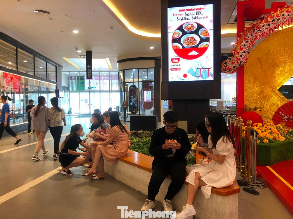 Không còn chỗ ngồi, nhiều khách hàng ngồi ngay lối đi lại thưởng thức bữa trưa ngon lành trước khi tiếp tục tham quan, vui chơi. "Suốt ba ngày Tết, tôi đã đưa con đi Thảo Cầm Viên, Đầm Sen, Suối Tiên... Nay chọn trung tâm thương mại để con vui chơi, ăn uống cho mát mẻ" - anh Hưng (nhân viên văn phòng, ngụ quận 3) cho hay.