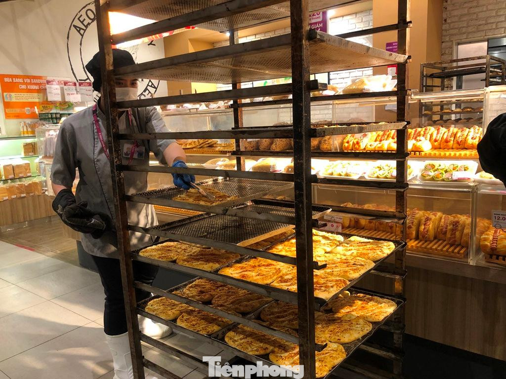 Nhân viên ra mẻ bánh mới nóng hổi phục vụ khách hàng.