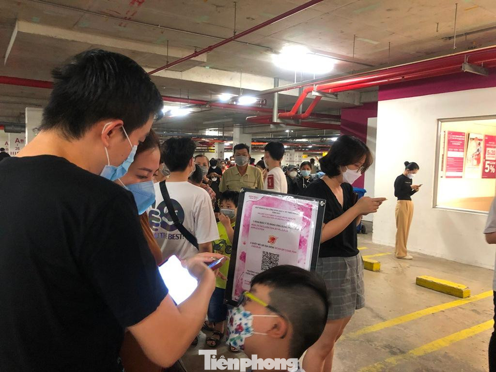 Một gia đình trẻ khai báo online khi vào trung tâm thương mại vui chơi những ngày Tết.