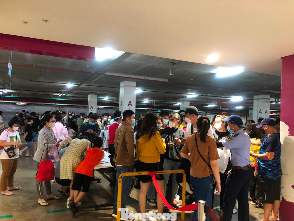 Hàng trăm người xếp hàng dài trình khai báo y tế, đồng thời bảo vệ đo nhiệt độ, xịt khử khuẩn trước khi vào trung tâm thương mại.