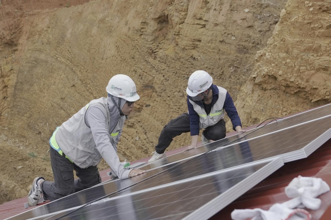 Các công nhân trẻ tích cực lắp đặt hệ thống điện năng lượng mặt trời.