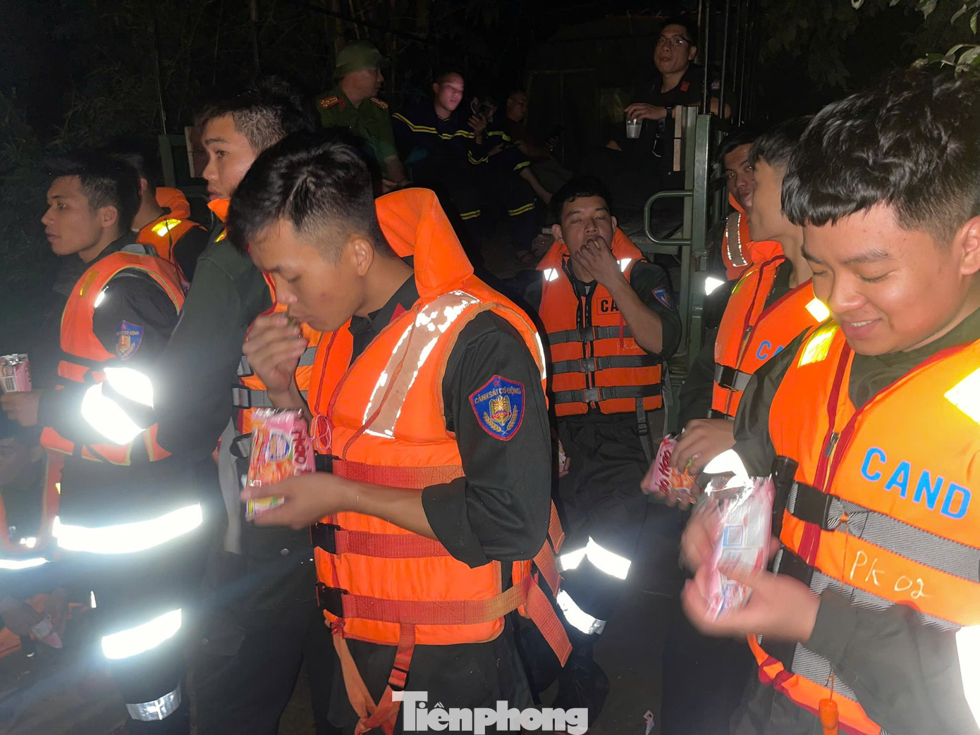 Các chiến sỹ Công an Lạng Sơn tranh thủ lót dạ rồi tiếp tục thực hiện công việc xuyên đêm cứu dân khỏi rốn lũ. Ảnh: C.H