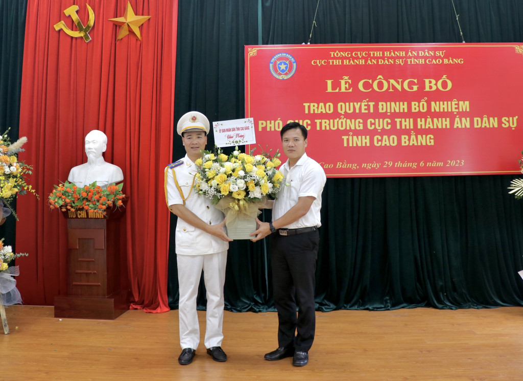 Phó Chủ tịch UBND tỉnh Cao Bằng Trịnh Trường Huy (bìa phải tặng hoa chúc mừng tân Phó Cục trưởng Thi hành án dân sự tỉnh. Ảnh: D.H