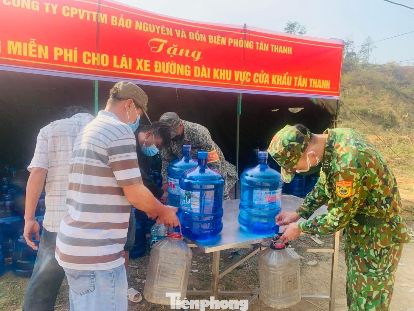 Lực lượng Biên phòng, nhân viên Công ty CPVTTM Bảo Nguyên giúp lấy nước vào các chai cho lái xe đường dài *Ảnh: Duy Chiến Lực lượng Biên phòng, nhân viên Công ty CPVTTM Bảo Nguyên giúp lấy nước vào các chai cho lái xe đường dài *Ảnh: Duy Chiến