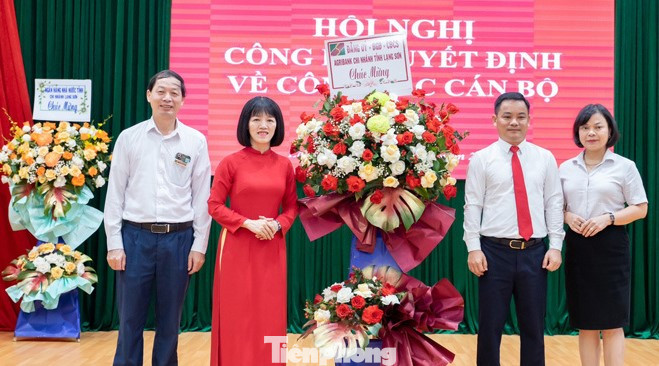 Bà Đinh Thị Hồng Giang (áo đỏ) nhận hoa chúc mừng. Ảnh: Duy Chiến