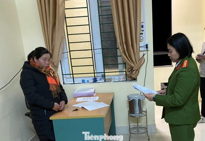 Đối tượng Hoàng Thị Ngân (bìa trái) nghe lệnh khởi tố, bắt tạm giam bị can -Ảnh: CB