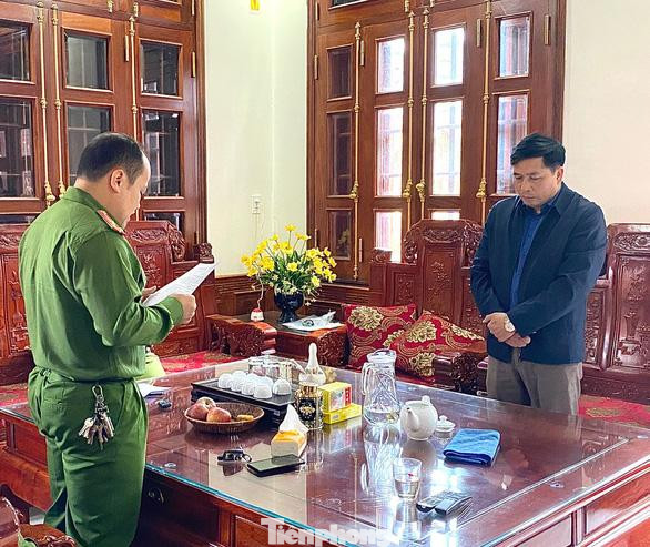 Ông Nguyễn Ích Chánh (bìa phải) nghe công bố quyết định khởi tố bị can -Ảnh: CB