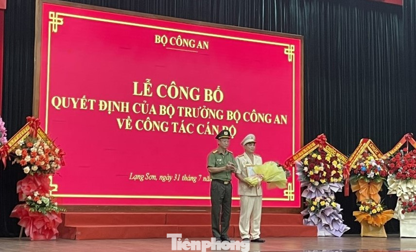 Thượng tá Nguyễn Quang Huyên (bìa phải) nhận Quyết định và hoa chúc mừng. Ảnh: Duy Chiến