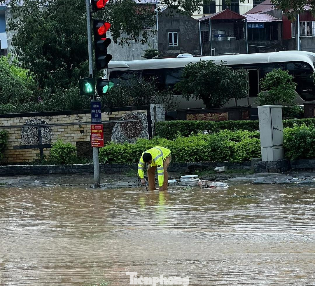 Chiến sỹ cảnh sát giao thông Công an Lạng Sơn vớt rác, khơi thông cống rãnh để nước rút nhanh.