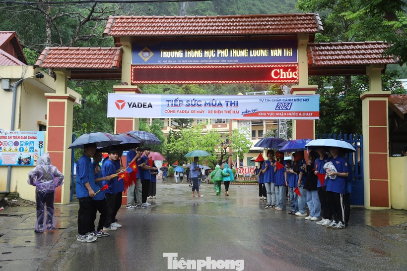 Thời tiết mưa gió bất thường, các tình nguyện viên sẵn sàng ô che cho thí sinh. Ảnh: N.C