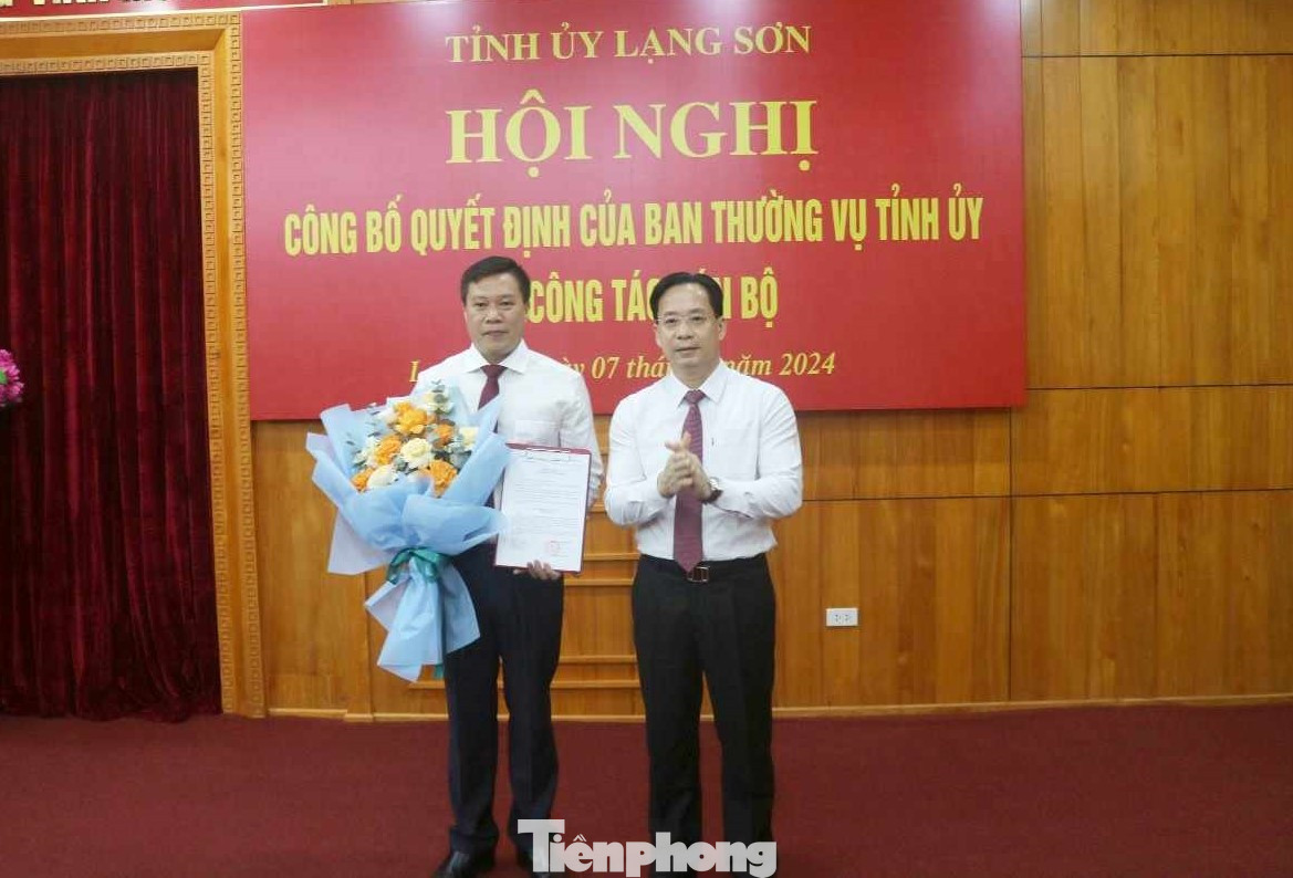 Ông Đinh Đức Chính (bìa trái) nhận quyết định, hoa chúc mừng của lãnh đạo Tỉnh ủy Lạng Sơn. Ảnh: Duy Chiến