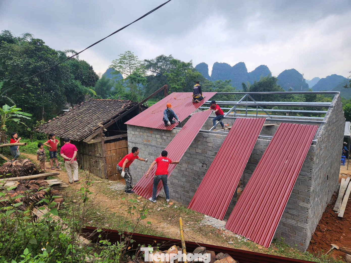 Các thợ trẻ thuộc CLB xe địa hình Lạng Sơn tiến hành lợp mái tôn cho nhà &quot;Khăn quàng đỏ&quot;. Ảnh: Duy Chiến