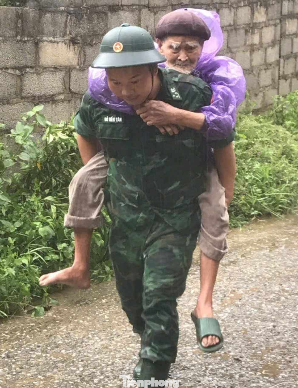 Cụ ông Lộc Viết Sòi (81 tuổi) được chiến sĩ Biên phòng di dời khỏi vùng nguy hiểm đến nơi an toàn.