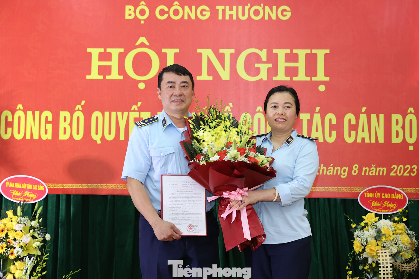 Ông Trần Mạnh Hùng (bìa trái) nhận Quyết định và hoa của lãnh đạo Tổng cục QLTT. Ảnh: A.D.
