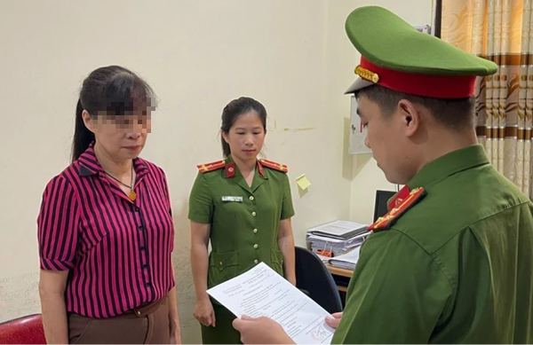 Bà Nghiệp (bìa trái) nghe quyết định khởi tố bị can,