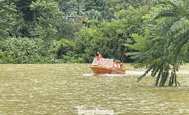 Lực lượng chức năng tiến hành tìm kiếm 2 người gặp nạn, đồng thời tuyên truyền nhân dân nâng cao tinh thần cảnh giác, phòng chống mưa lũ. Ảnh: V.T