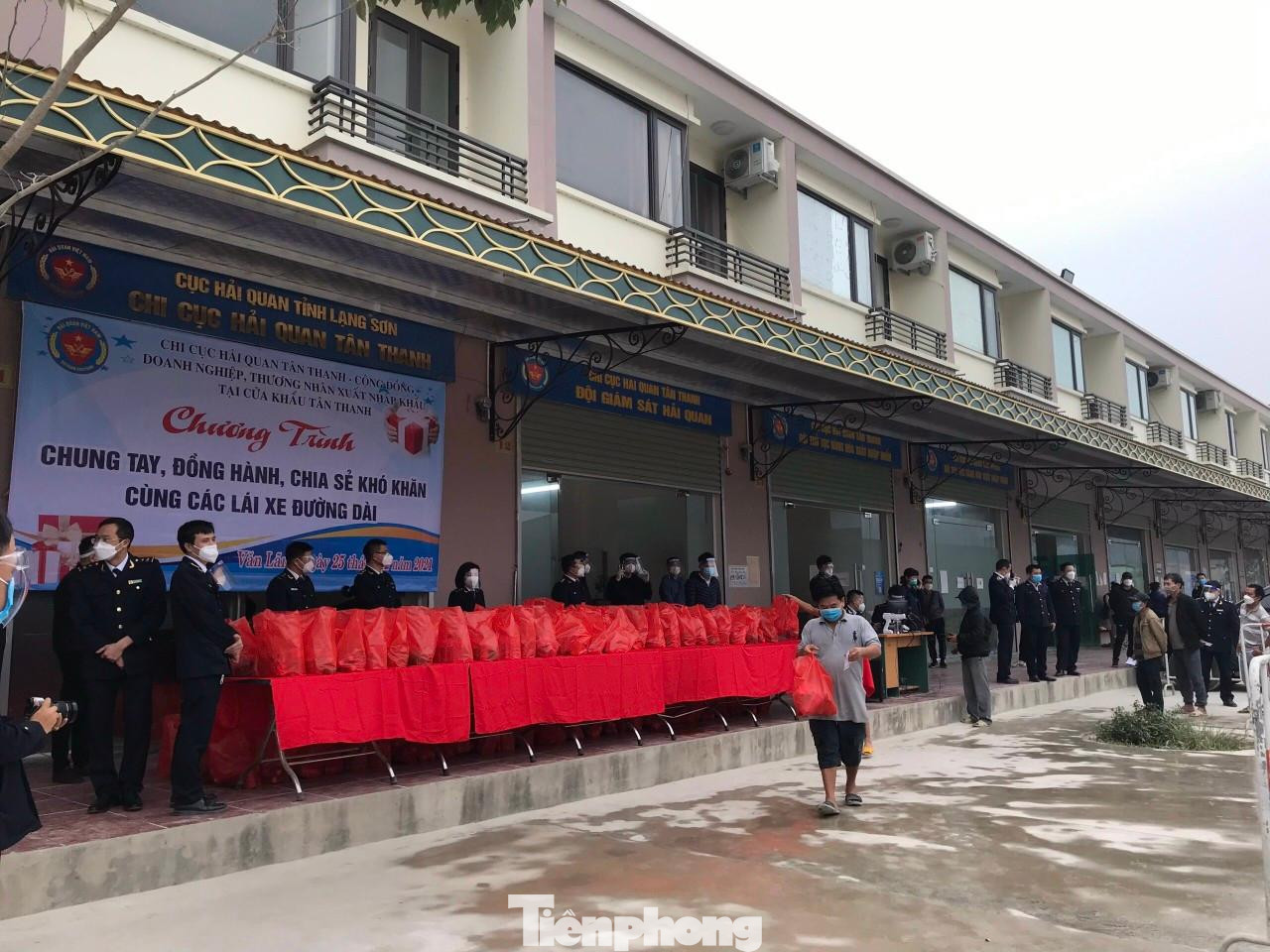 Các lái xe đường dài vừa tiếp nhận quà, vừa đảm bảo công tác phòng chống dịch bệnh -Ảnh: Duy Chiến