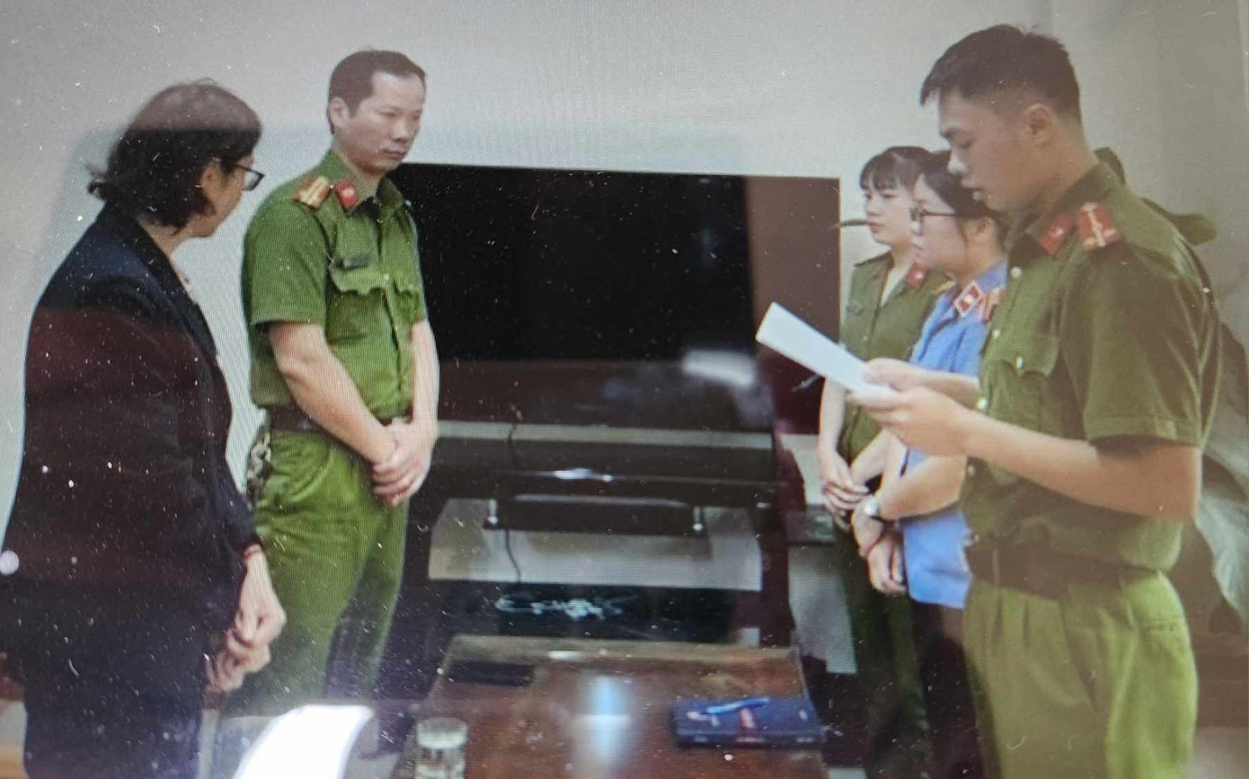 Đối tượng Hoàng Thị minh Hiền (bìa trái) nghe lệnh bắt tạm giam.