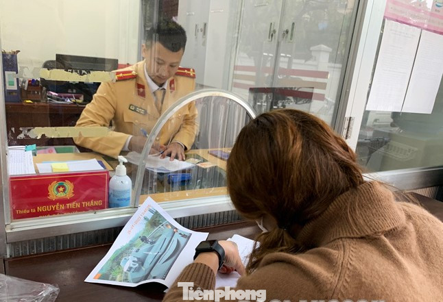 Bà H, lái xe vi phạm ký biên bản xử lý vi phạm -Ảnh: LS