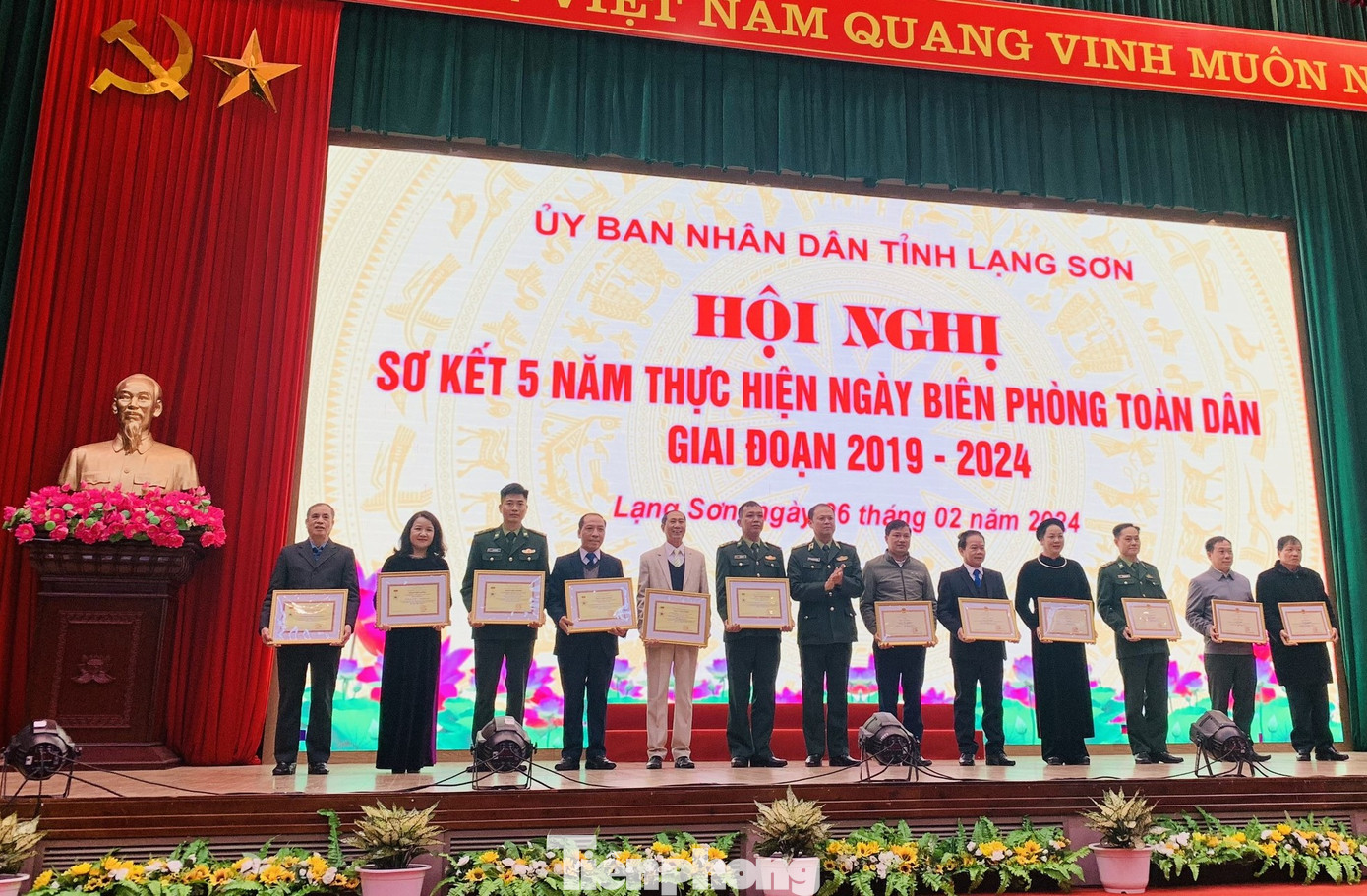 Phóng viên báo Tiền Phong (giữa) nhận Kỷ niệm chương "Vì chủ quyền an ninh biên giới Tổ quốc) của Bộ Tư lệnh Biên phòng.