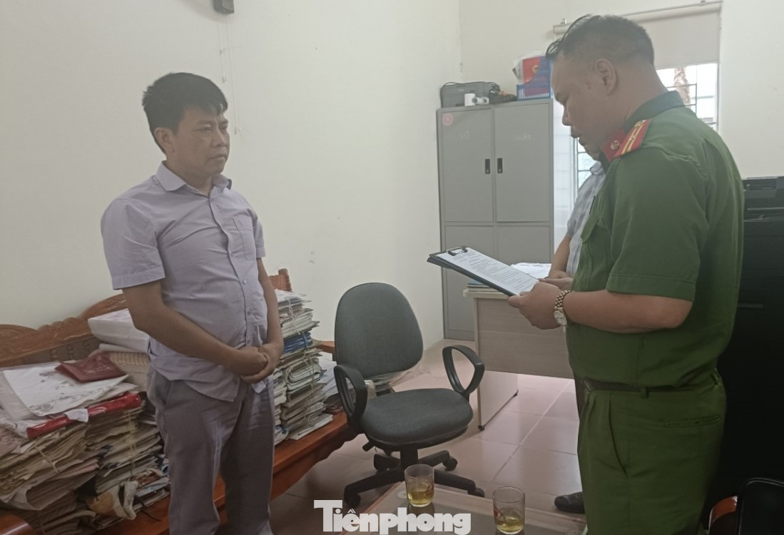 Đối tượng Nông Văn Thuận (bìa trái) nghe quyết định khởi tố bị can. Ảnh: CB