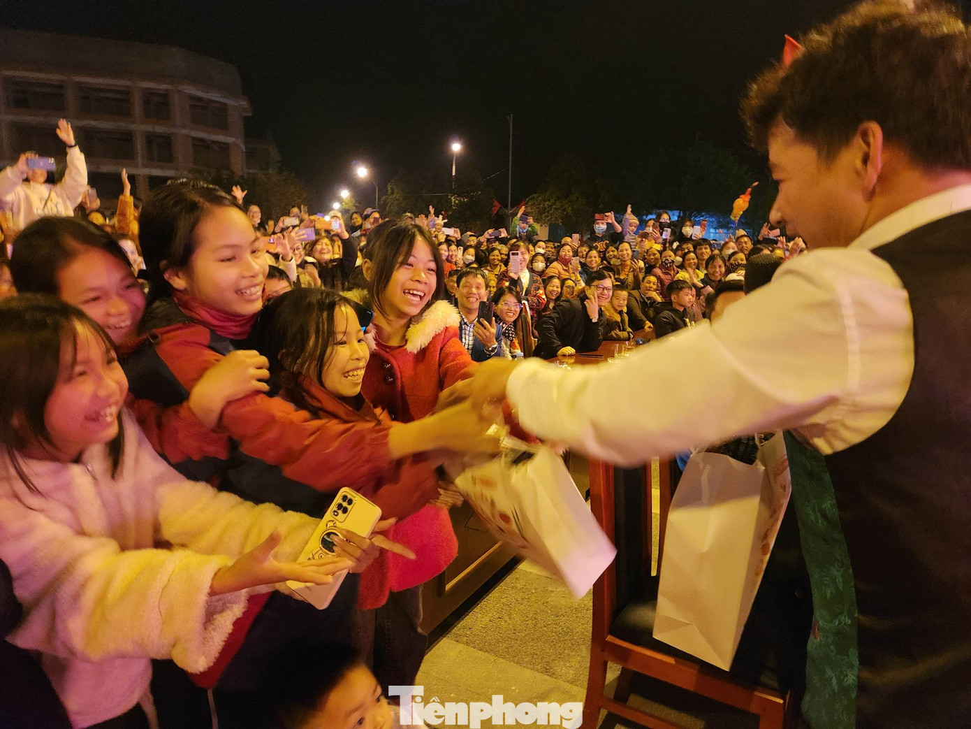 Trẻ em hào hứng nhận quà của nghệ sĩ Xuân Bắc.