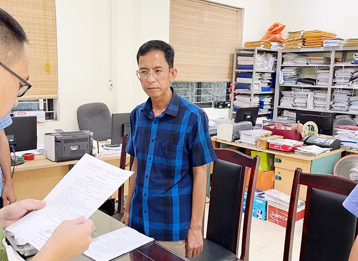 Ông Nông Văn Cán (bìa phải) nghe lệnh khởi tố bị can, khám xét nơi làm việc. Ảnh: CB Ông Nông Văn Cán (bìa phải) nghe lệnh khởi tố bị can, khám xét nơi làm việc. Ảnh: CB