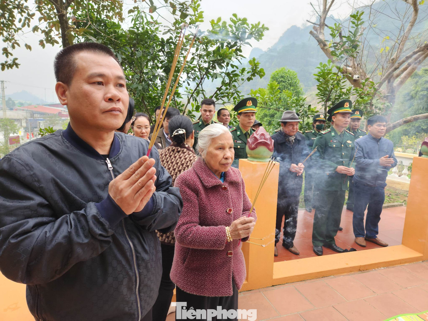 Trung tá Nguyễn Ngọc Liêm và bà Nguyễn Thúy Lan (ngoài cùng bên trái) thắp nhang tưởng nhớ chồng, cha mình là liệt sỹ Nguyễn Ngọc Linh. Ảnh: Duy Chiến