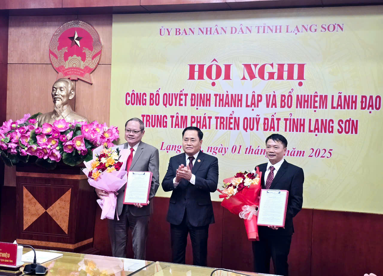 Chủ tịch UBND tỉnh Lạng Sơn trao quyết định, tặng hoa chúc mừng Giám đốc, Phó giám đốc Trung tâm Phát triển quỹ đất tỉnh. Ảnh: Duy Chiến