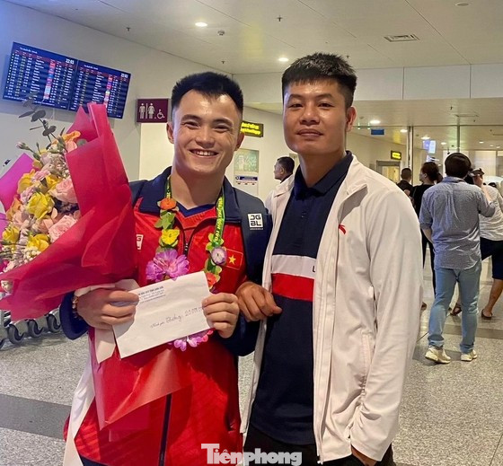 Nông Văn Hữu (bìa trái) và huấn luyện viên Trần Văn Quyết. Ảnh: TL