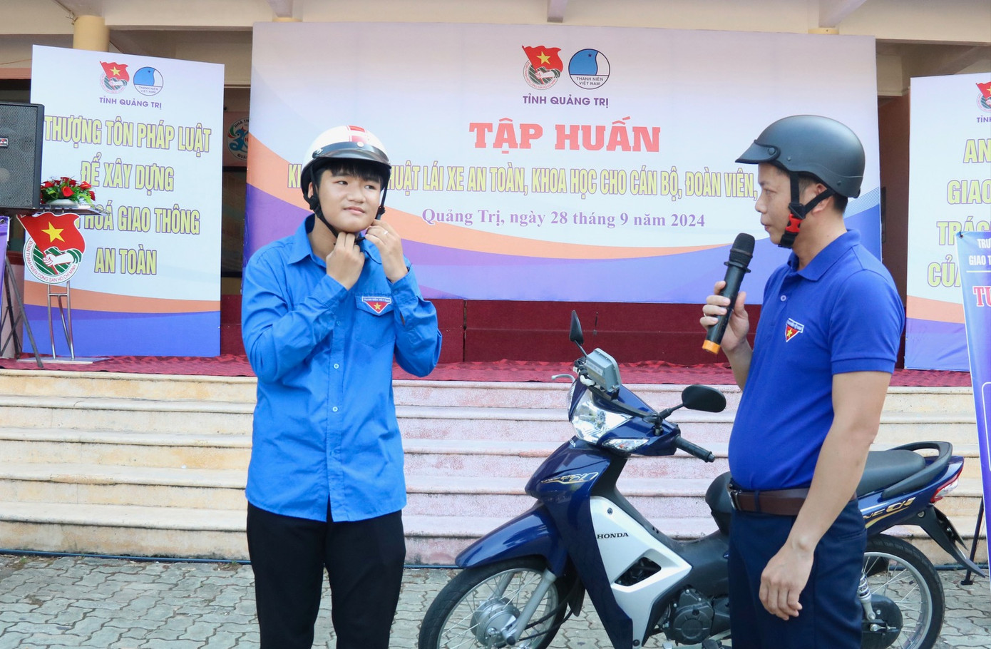 Giáo viên Trường Trung cấp Nghề Giao thông vận tải Quảng Trị hướng dẫn đoàn viên thanh niên đội mũ bảo hiểm đúng cách. Giáo viên Trường Trung cấp Nghề Giao thông vận tải Quảng Trị hướng dẫn đoàn viên thanh niên đội mũ bảo hiểm đúng cách.