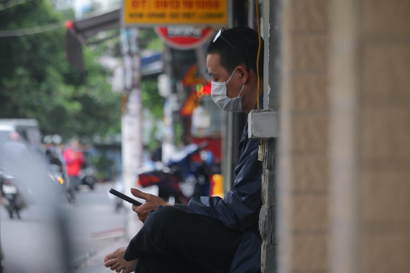 Một phụ huynh lướt tin tức trong lúc chờ con làm bài thi tiếng Ngoại ngữ - Ảnh: Ngọc Long Một phụ huynh lướt tin tức trong lúc chờ con làm bài thi tiếng Ngoại ngữ - Ảnh: Ngọc Long