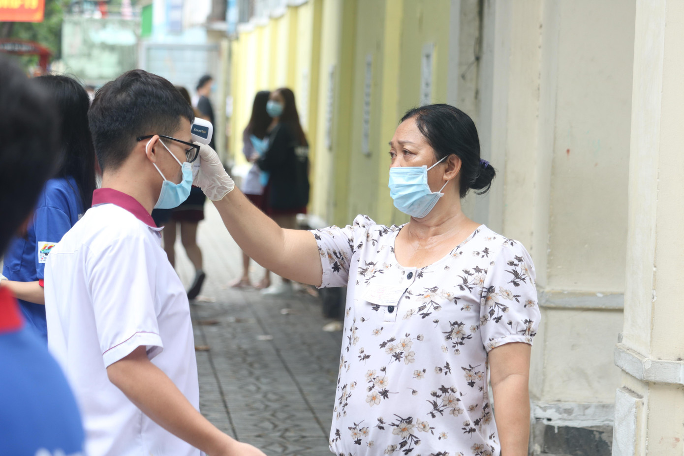 100% thí sinh được đo thân nhiệt và sát khuẩn tay trước khi bước vào điểm thi - Ảnh: Viên Vy