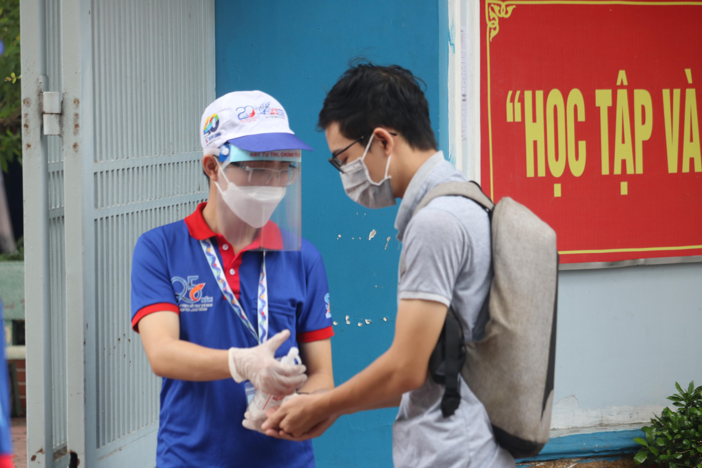 Thí sinh được khử khuẩn và đo thân nhiệt tại cổng - Ảnh: Ngọc Long