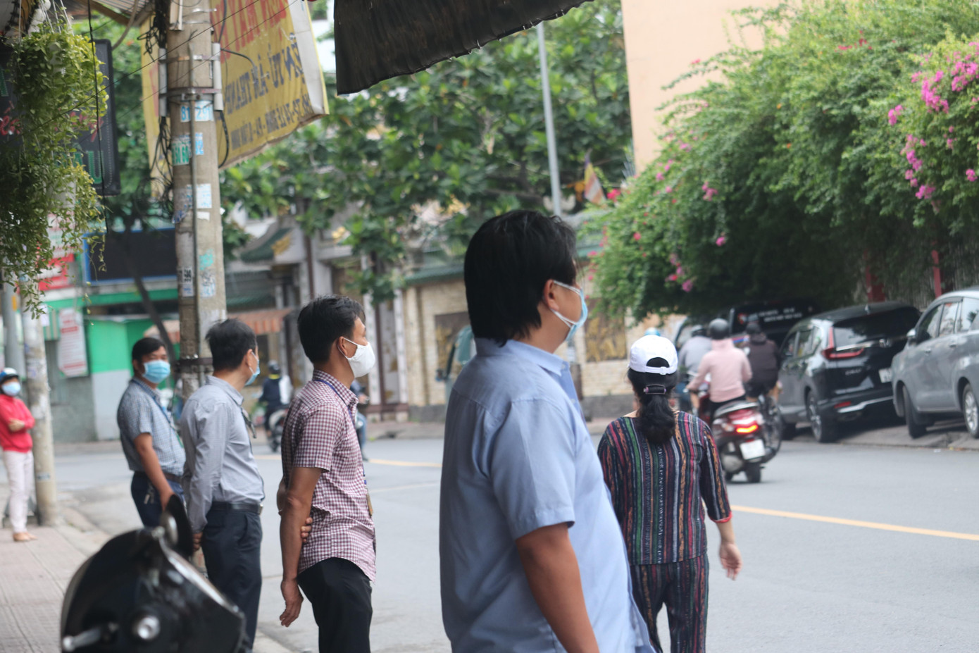 Phụ huynh đứng giãn cách tối thiểu 2m phía bên kia đường nhìn con bước vào điểm thi - Ảnh: Ngọc Long Phụ huynh đứng giãn cách tối thiểu 2m phía bên kia đường nhìn con bước vào điểm thi - Ảnh: Ngọc Long