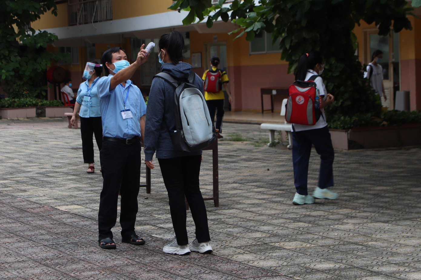 Việc đo thân nhiệt được tiến hành trong khuôn viên trường thay vì trước cổng để tạo giãn cách - Ảnh: Viên Vy Việc đo thân nhiệt được tiến hành trong khuôn viên trường thay vì trước cổng để tạo giãn cách - Ảnh: Viên Vy