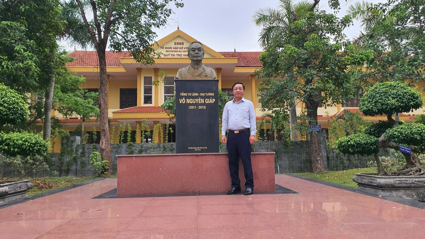 Thầy giáo Hoàng Thanh Cảnh đứng bên bức tượng Đại tướng được đặt trang trọng giữa khuôn viên Trường chuyên Võ Nguyên Giáp.