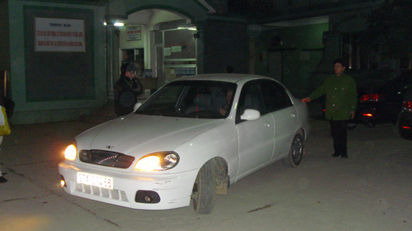 Ông Thắng (bên trái nhìn từ ngoài vào) lên xe. Ngoài 3 cảnh sát áp giải, có hai thân nhân của ông Thắng được phép đi cùng