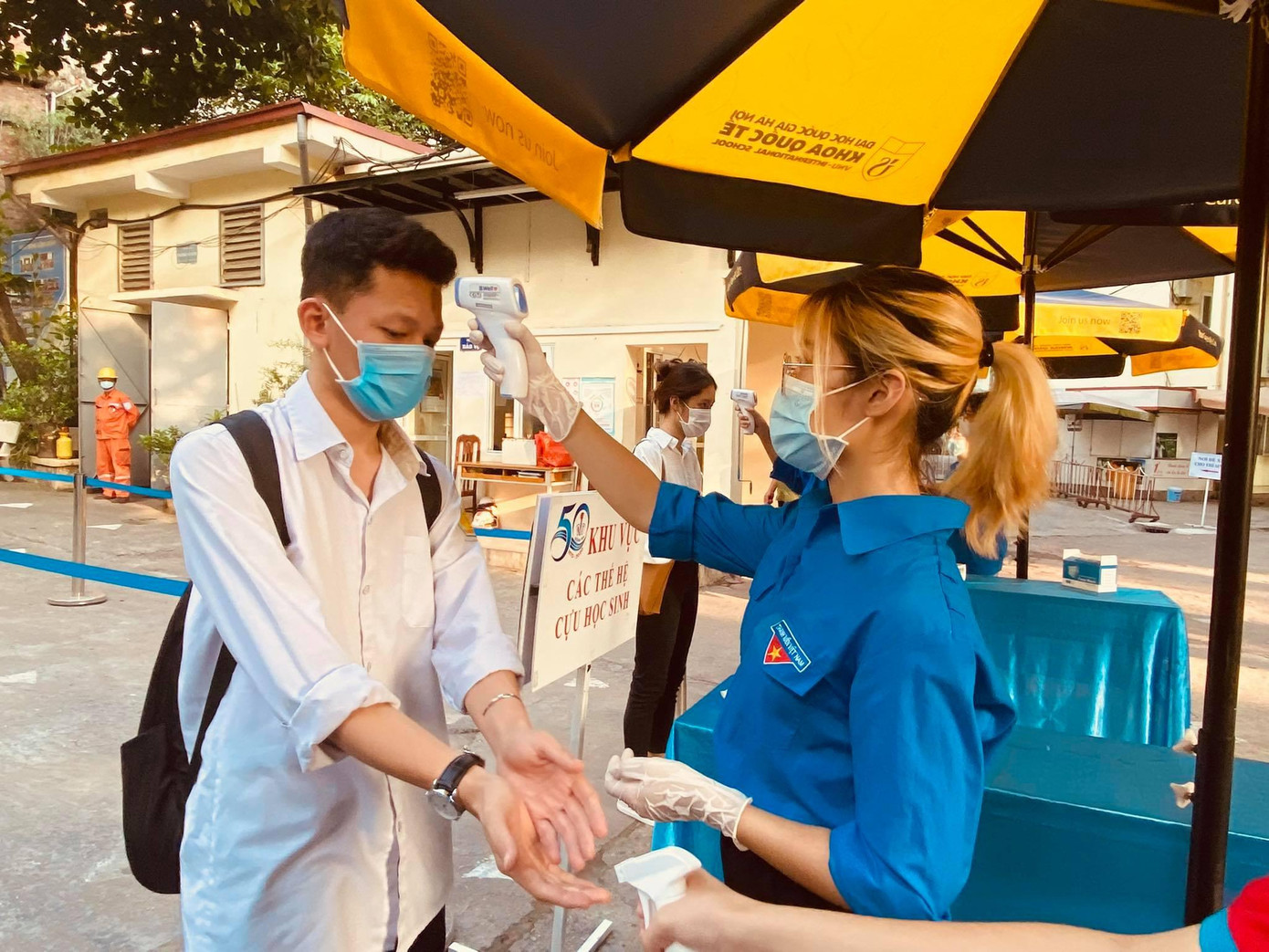 Thí sinh được sát khuẩn, kiểm tra thân nhiệt kỹ càng trước khi vào phòng thi. Ảnh chụp tại điểm thi THPT Quang Trung, quận Đống Đa (Hà Nội).