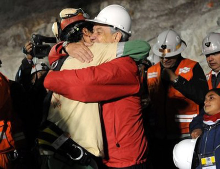 Florencio Avalos là người đầu tiên được Tổng thống Chile Sebastian Pinera ôm hôn sau khi lên được đến mặt đất. Ảnh: AP