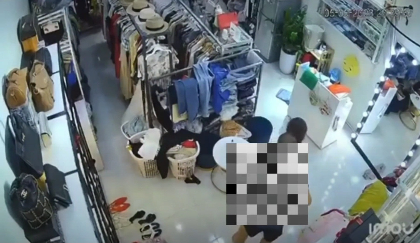 Hình ảnh nghi phạm khống chế nạn nhân trong quán thời trang được camera ghi lại. Ảnh cắt từ camera
