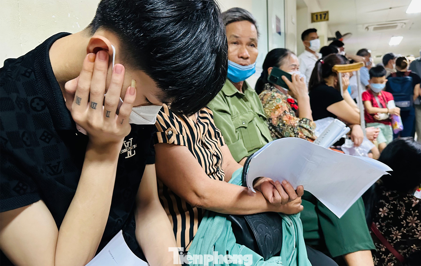 Từng nhóm người ngồi chờ đợi kết quả khám, chữa bệnh. Tình trạng quá đông bệnh nhân và tình trang xếp hàng chờ đợi quá lâu khiến người bệnh càng trở nên mệt mỏi.