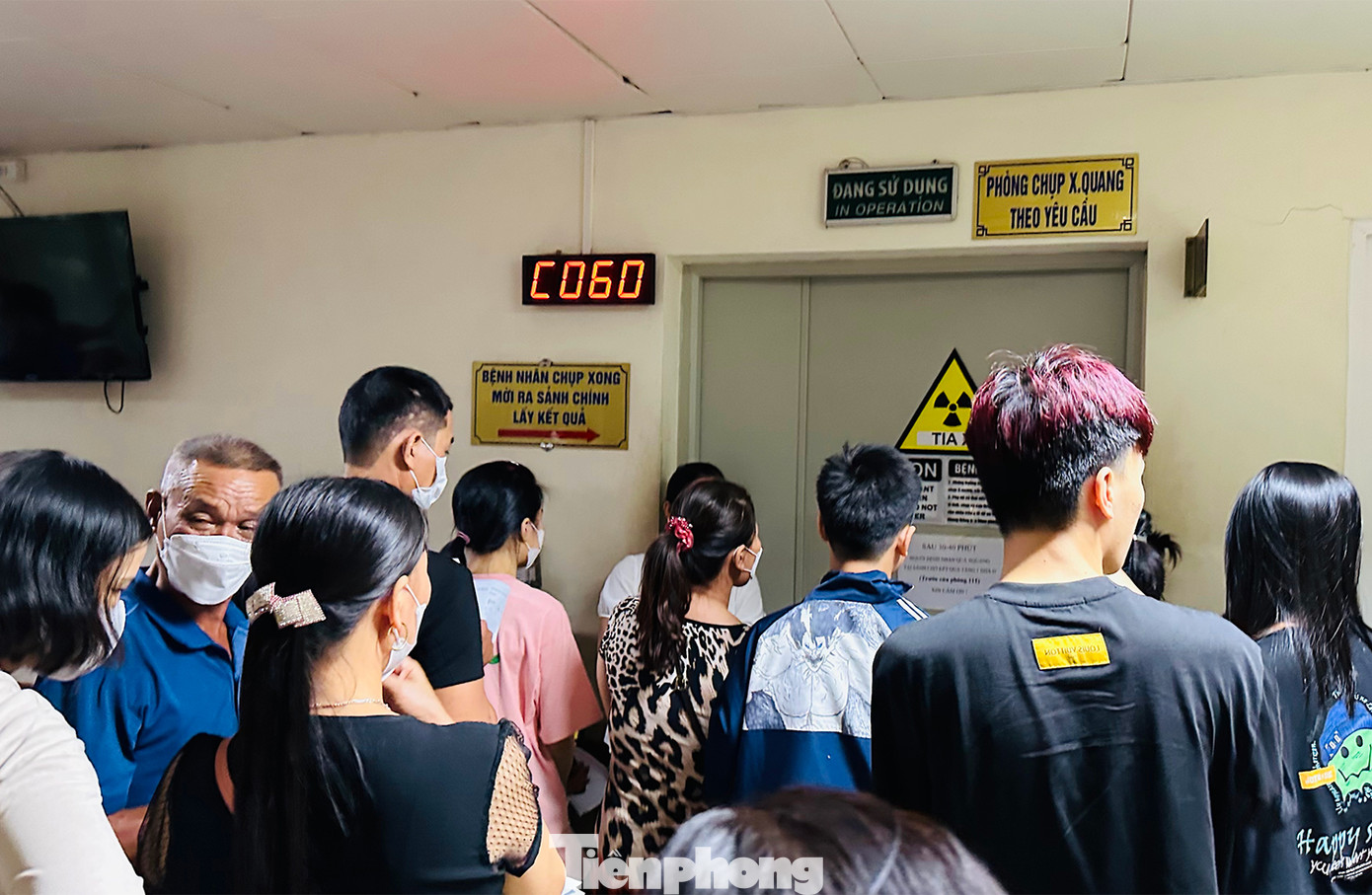 Trước cửa phòng chụp X-quang bệnh nhân chen chân đứng chờ xếp hàng đến lượt chụp.